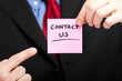 Businessman showing the words contact us