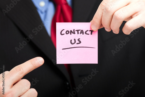 Photo: Businessman showing the words contact us Businessman showing the words contact us