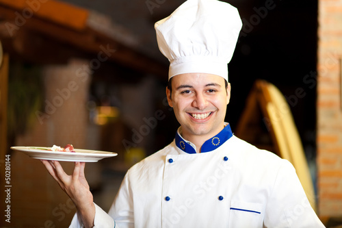 Photo: Chef holding a dish in a restaurant Chef holding a dish in a restaurant