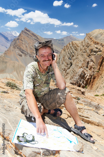 Photo: Tourist hiker with map in mountains Tourist hiker with map in mountains