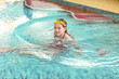 Happy girl with goggles in swimming pool