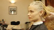 Professional female hairdresser dyeing female customer