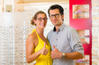 Young couple at optician with glasses