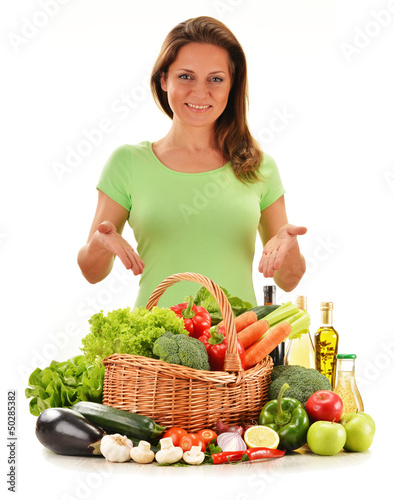 Photo: Young woman with variety of vegetables isolated on white Young woman with variety of vegetables isolated on white