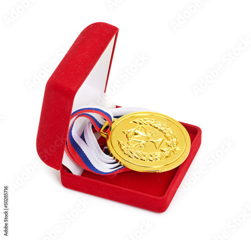 Photo: Golden medal in red gift box. Golden medal in red gift box.