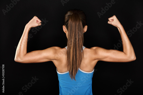 Photo: Strong fitness woman showing back biceps muscles Strong fitness woman showing back biceps muscles