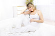 Young pregnant woman sitting on sofa