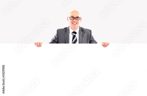 Photo: Happy smiling young business man showing blank signboard Happy smiling young business man showing blank signboard