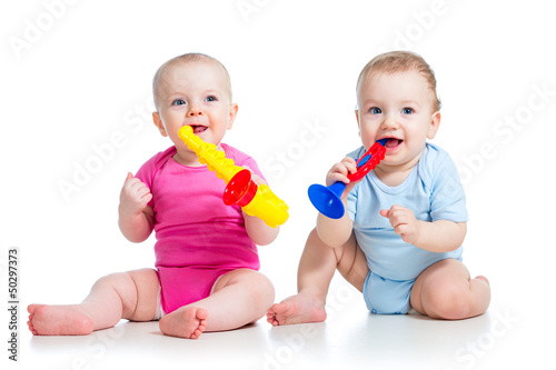 Photo: Funny children girl and boy playing with musical toy. Isolated o Funny children girl and boy playing with musical toy. Isolated o