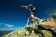 Hiker jumps over stones in Carpathian mountains