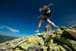 Hiker jumps over stones in Carpathian mountains