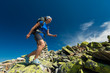 Hiker jumps over stones in Carpathian mountains