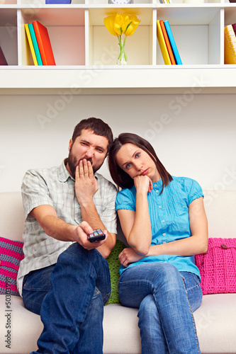 Photo: bored couple watching TV bored couple watching TV