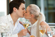 Cute couple kissing at dinner table.