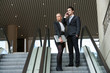 Photo: Young business couple on escalator. Young business couple on escalator.