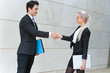 Photo: Young buisness couple shaking hands over deal. Young buisness couple shaking hands over deal.