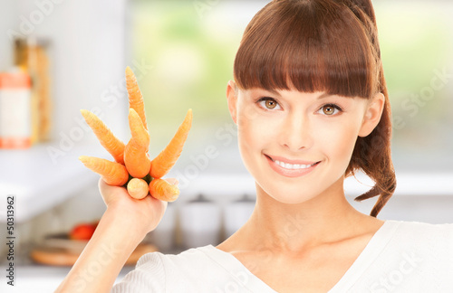 Photo: housewife with carrots at the kitchen housewife with carrots at the kitchen