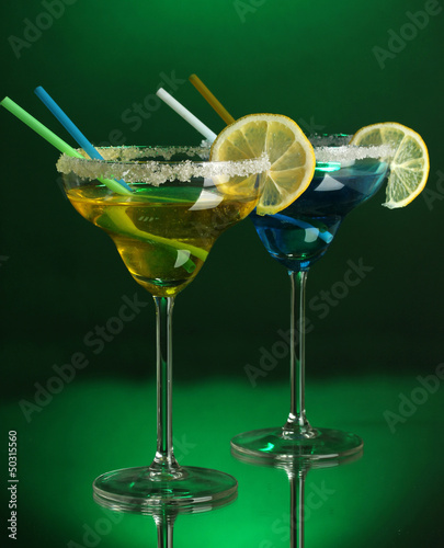 Photo: Yellow and blue cocktails in glasses on color background Yellow and blue cocktails in glasses on color background
