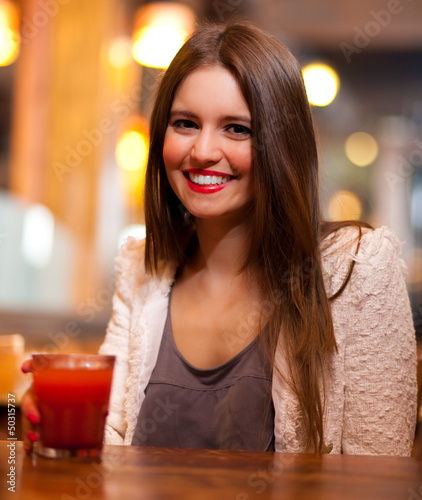 Photo: Young woman drinking in a bar Young woman drinking in a bar