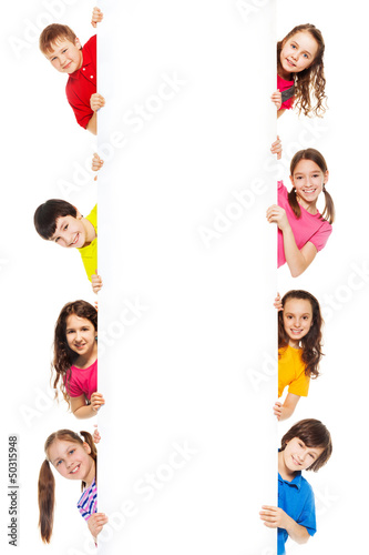 Photo: Six kids looking from blank billboard Six kids looking from blank billboard