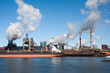 Foto: Big ship in front of a large steel factory in IJmuiden, Netherla Big ship in front of a large steel factory in IJmuiden, Netherla
