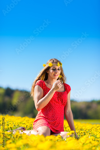 Photo: Girl in spring on a flower meadow with dandelion Girl in spring on a flower meadow with dandelion
