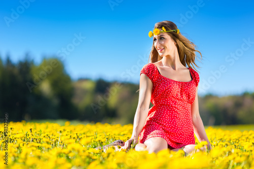 Photo: Girl in spring on a flower meadow with dandelion Girl in spring on a flower meadow with dandelion
