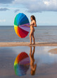 Young naked girl with a colorful umbrella
