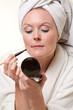 Beautiful danish caucasian woman doing her makeup in white