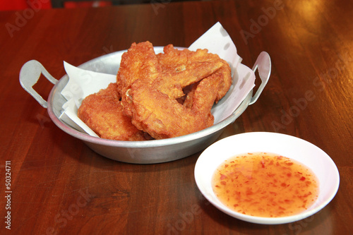 Photo: Fried chicken wings on wooden floors. Fried chicken wings on wooden floors.