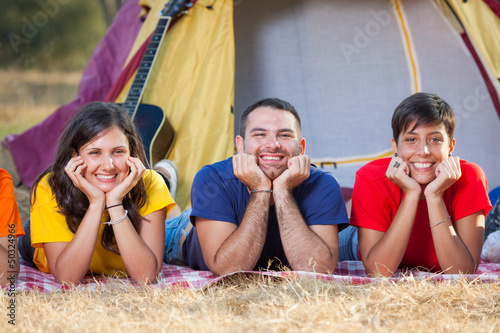 Photo: Young People Laying on the Ground on Camping Young People Laying on the Ground on Camping