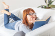 Photo: Beautiful Young Woman with a Book on the Sofa Beautiful Young Woman with a Book on the Sofa