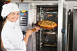 Beautiful Chef Placing Pizza In Oven