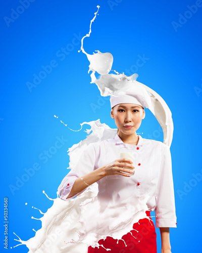 Photo: Asian female cook against milk splashes Asian female cook against milk splashes