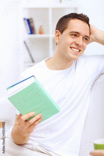 Photo: Young man at home with a book Young man at home with a book