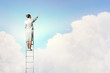 Businesswoman standing on ladder