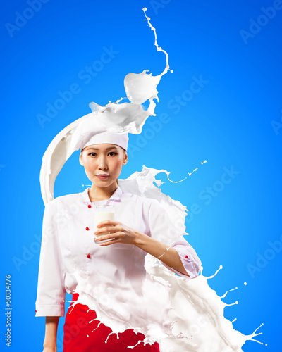 Photo: Asian female cook against milk splashes Asian female cook against milk splashes