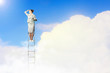 Businesswoman standing on ladder