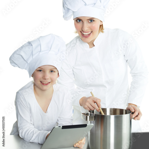 Photo: Mother and daughter using electronic tablet for cooking Mother and daughter using electronic tablet for cooking