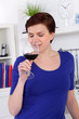 young woman enjoying a glass of red wine in her kitchen
