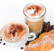Kaffe, Latte Macchiato und Croissant vor weißem Hintergrund