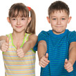 Two children hold their thumbs up