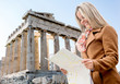 Photo: Woman holding a map in Athens Woman holding a map in Athens