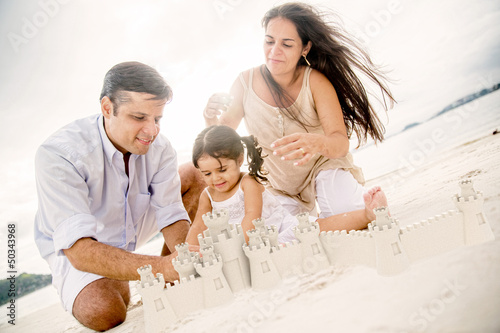 Photo: Family building sand castles Family building sand castles