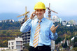 Photo: Young architect wearing a protective helmet standing on the moun Young architect wearing a protective helmet standing on the moun