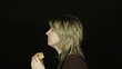 Woman eating hamburger on a black background (timelapse)