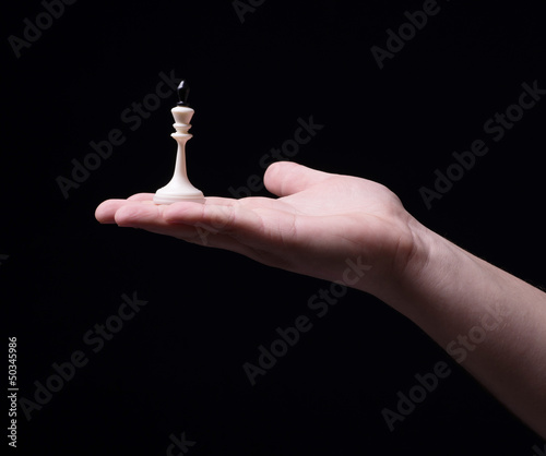 Photo: Chess in hand on a black background Chess in hand on a black background