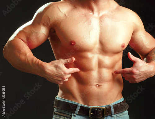 Photo: Muscular young man showing abs. Muscular young man showing abs.