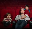 Man with boy in cinema with funny guy behind them