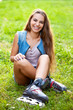 girl wearing roller skates sitting on grass